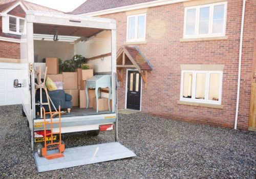 removal truck waiting to be unloaded outside new home on moving day